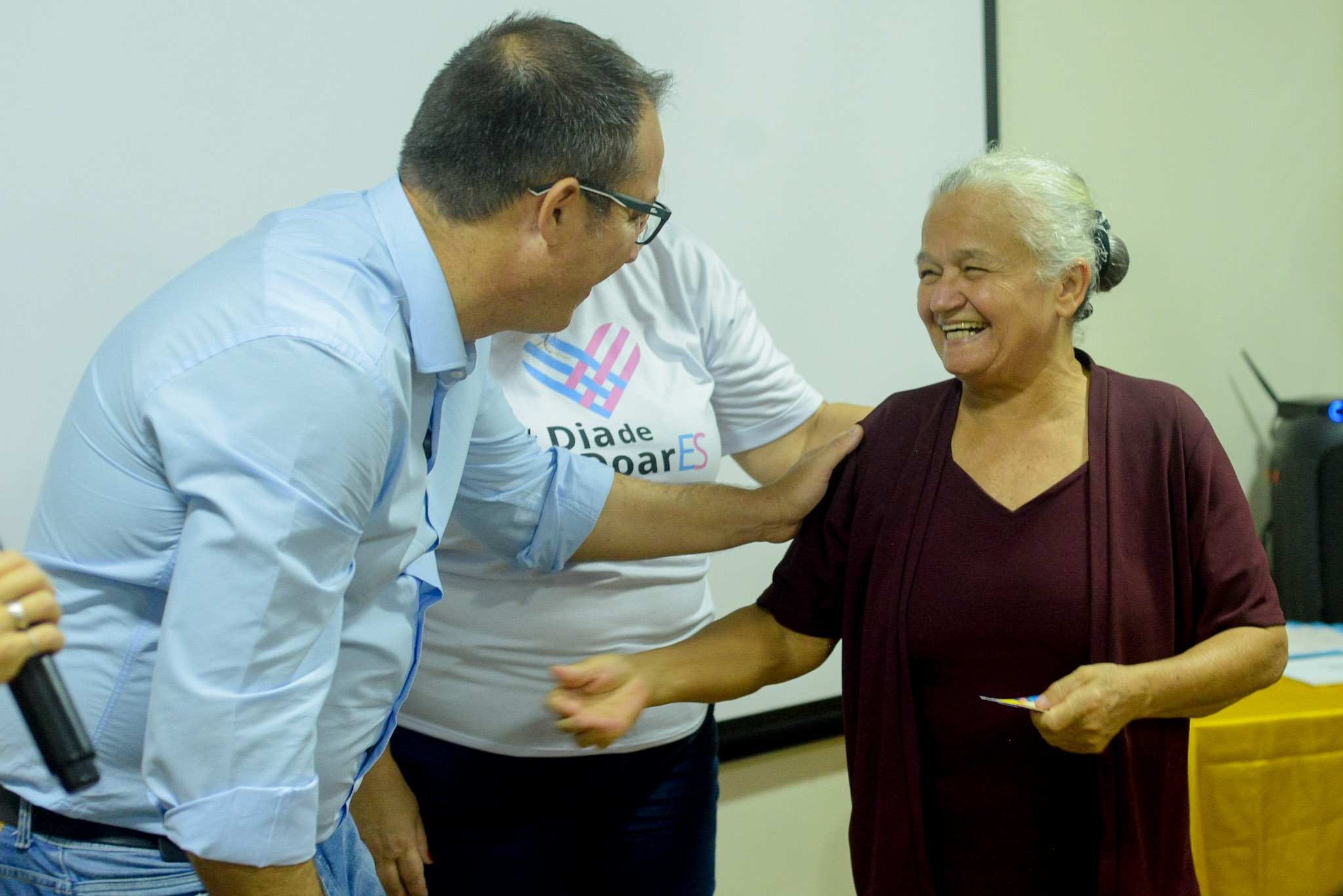Marcel Carone conversa com uma senhora idosa em evento